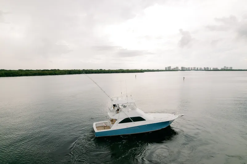 Slide: The Image of 2003 Viking 48 Convertible yacht cruising on calm waters under cloudy skies. - 6