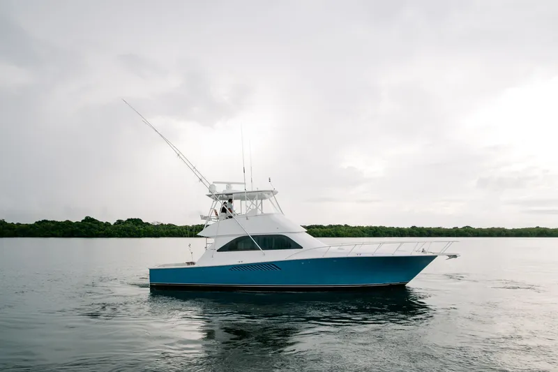 Slide: The Image of 2003 Viking 48 Convertible yacht on calm water under cloudy sky. - 10