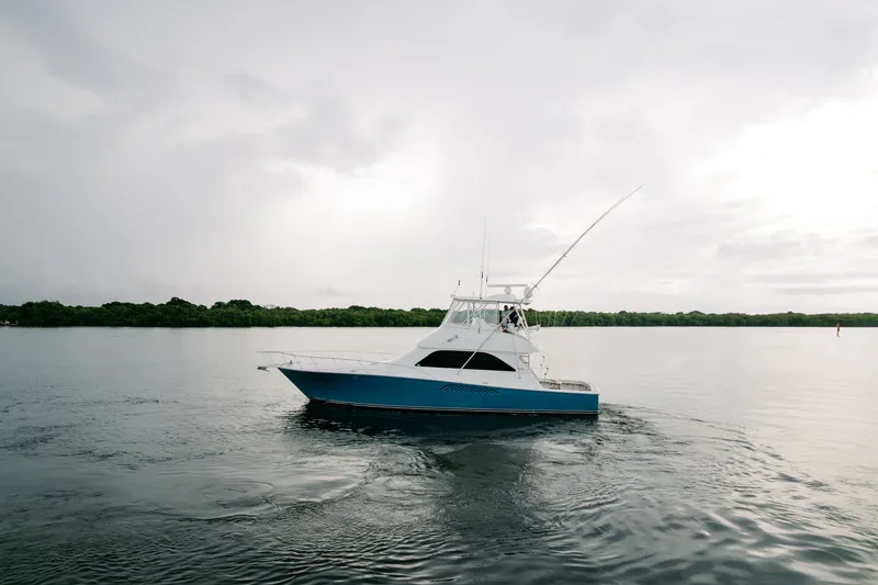 Slide: The Image of 2003 Viking 48 Convertible yacht cruising on calm waters under cloudy skies. - 2