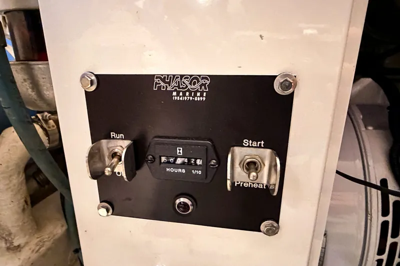 Slide: The Image of Control panel of a 2003 Viking 48 Convertible boat with hour meter and switches. - 32