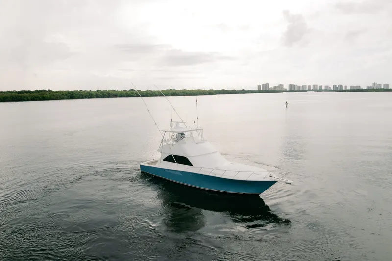 Slide: The Image of 2003 Viking 48 Convertible yacht cruising on calm waters under cloudy skies. - 7