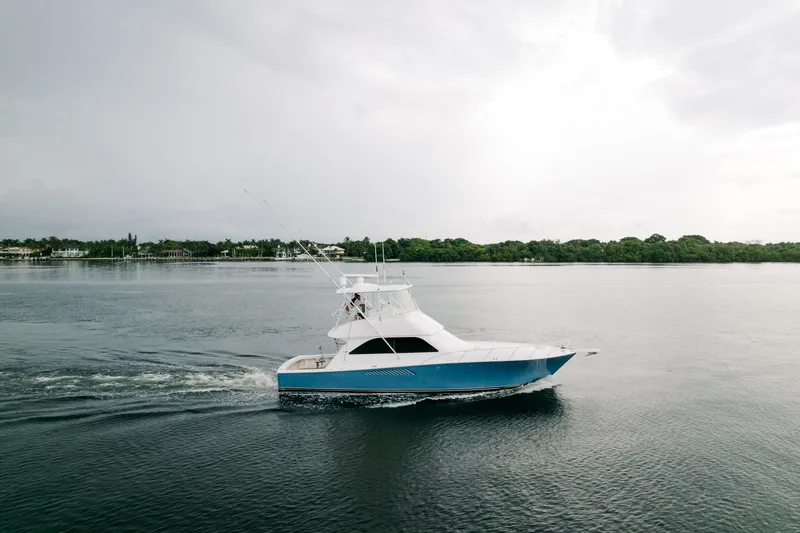 Slide: The Image of 2003 Viking 48 Convertible yacht cruising on calm waters under a cloudy sky. - 12