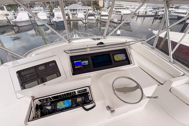 Slide: The Image of Helm of 2003 Viking 48 Convertible yacht with navigation equipment and marina view. - 26