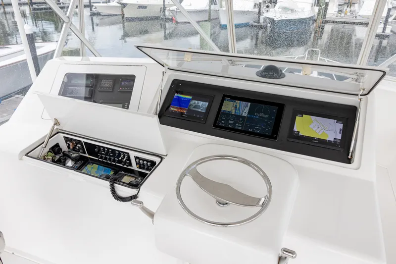 Slide: The Image of Control panel of a 2003 Viking 48 Convertible yacht with navigation screens and steering wheel. - 25