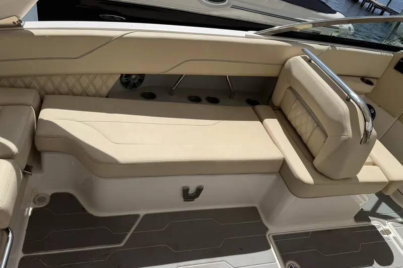 Slide: The Image of Luxurious seating area on a 2019 Regal LS6 boat, featuring beige upholstery and cup holders. - 17