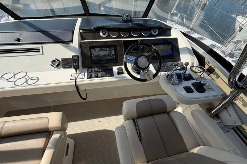 Slide: The Image of Cockpit of 2012 Sea Ray 450 Sedan Bridge with steering wheel and navigation controls. - 48