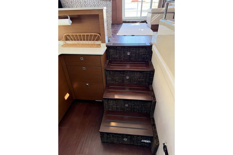 Slide: The Image of Interior stairs of 2012 Sea Ray 450 Sedan Bridge yacht, featuring wooden steps and modern design. - 44