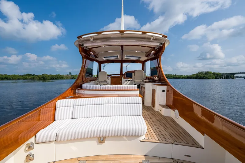 Slide: The Image of 2022 Hinckley Picnic Boat 40 on serene water, showcasing elegant deck and seating. - 6