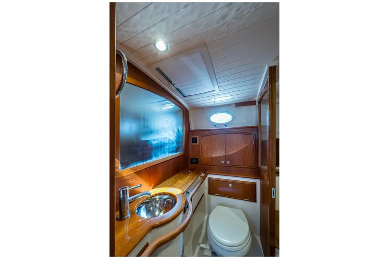 Slide: The Image of Luxurious 2022 Hinckley Picnic Boat 40 bathroom with wooden cabinetry and modern fixtures. - 15