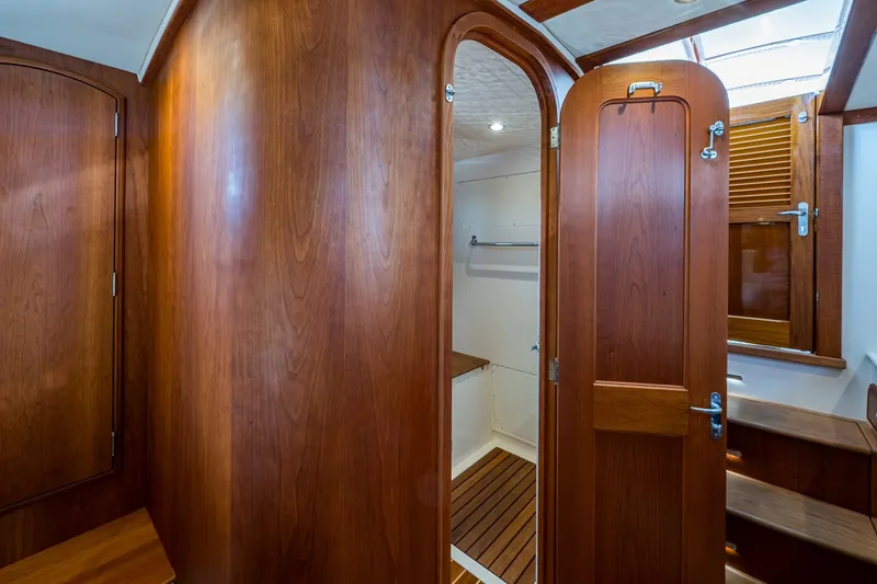 Slide: The Image of Interior of 2022 Hinckley Picnic Boat 40, featuring elegant wooden cabinetry and doors. - 14