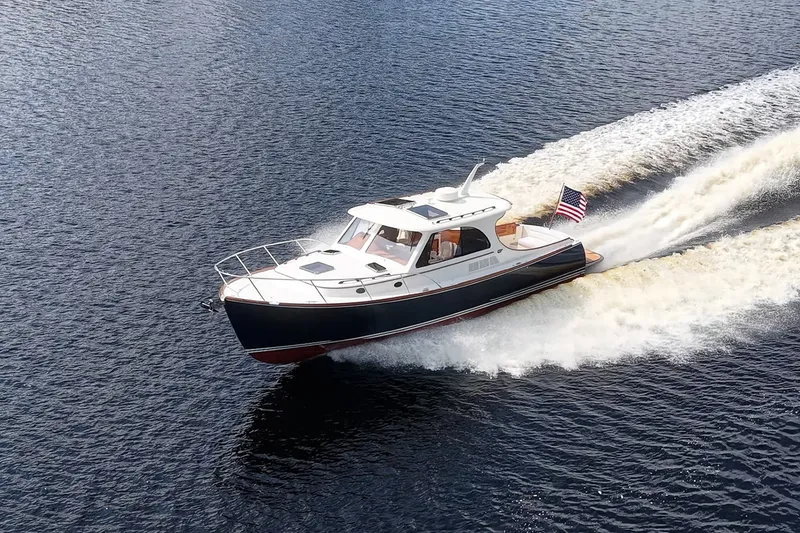 Slide: The Image of 2022 Hinckley Picnic Boat 40 cruising on open water, displaying American flag. - 3