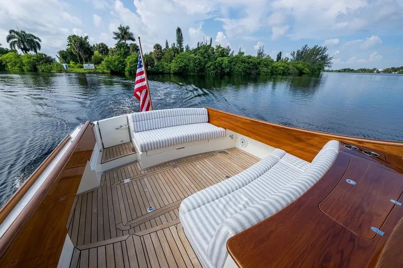 Slide: The Image of Hinckley Picnic Boat 40, 2022 model, with elegant seating and American flag on calm water. - 5
