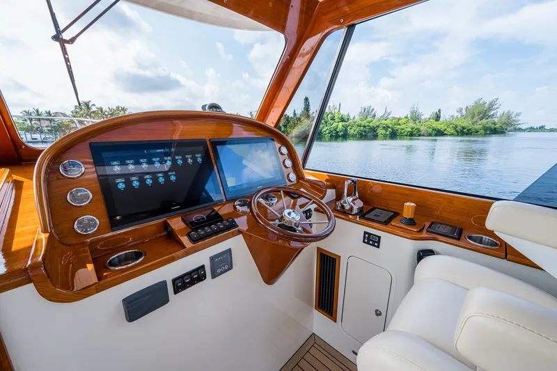 Slide: The Image of Helm of 2022 Hinckley Picnic Boat 40 with modern controls and scenic water view. - 12