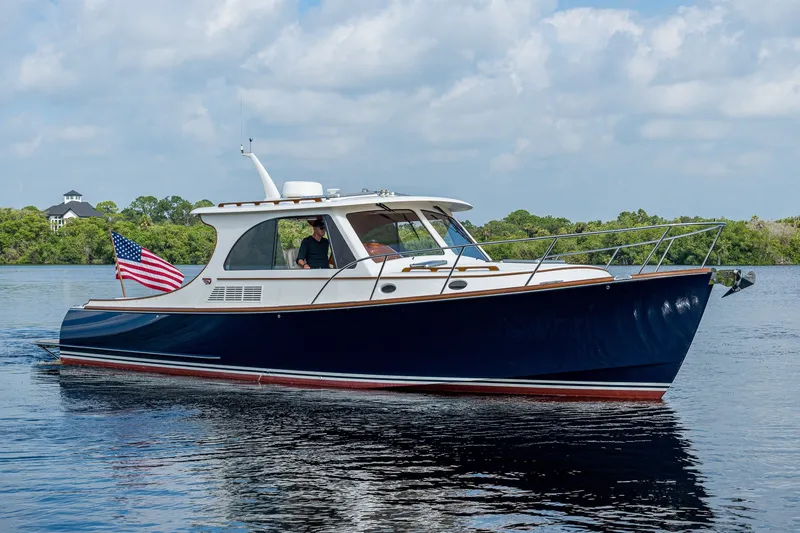Slide: The Image of 2022 Hinckley Picnic Boat 40 cruising on a calm river under a blue sky. - 2
