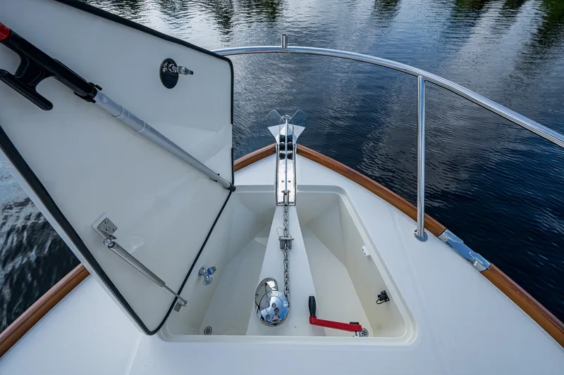 Slide: The Image of Hinckley Picnic Boat 40 (2022) anchor compartment with open hatch, on calm water. - 18