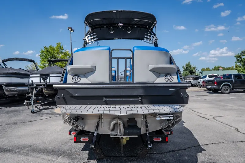 Slide: The Image of 2025 Montara 25 Surf Boss boat, rear view, parked outdoors under a clear blue sky. - 4