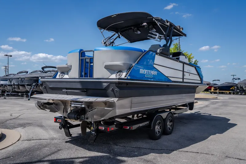 Slide: The Image of 2025 Montara 25 Surf Boss boat on trailer under clear blue sky. - 11