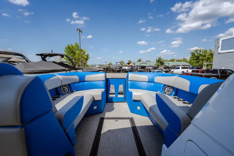 Slide: The Image of 2025 Montara 25 Surf Boss boat interior with blue seating under a clear sky. - 35