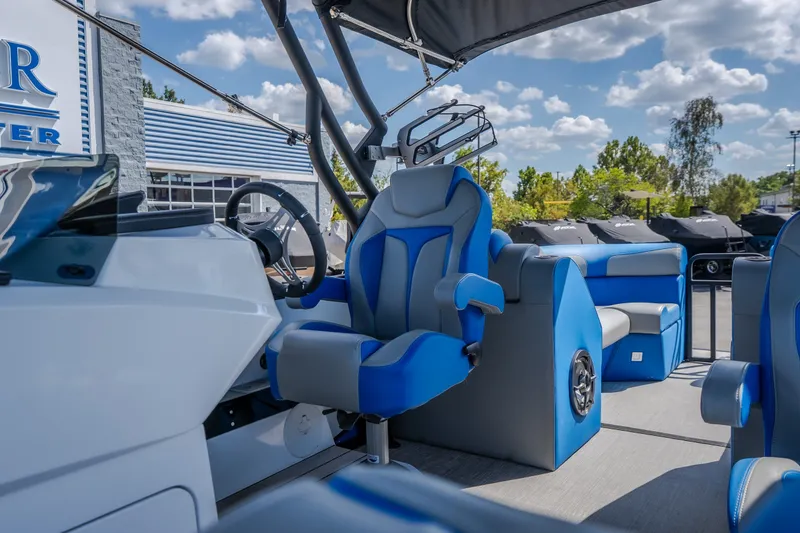 Slide: The Image of Interior view of 2025 Montara 25 Surf Boss boat with blue seating and steering wheel. - 24