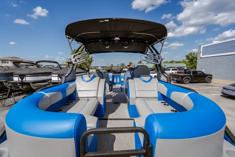 Slide: The Image of 2025 Montara 25 Surf Boss boat with blue and gray seating, parked outdoors. - 38