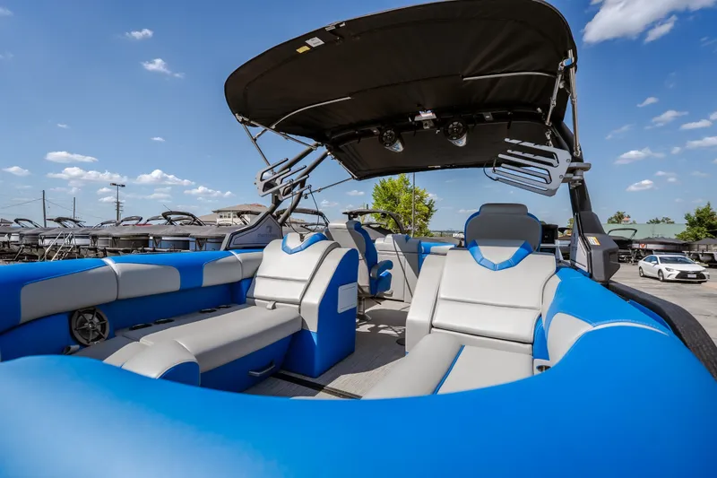 Slide: The Image of 2025 Montara 25 Surf Boss boat with blue and gray seating, under a sunny sky. - 42