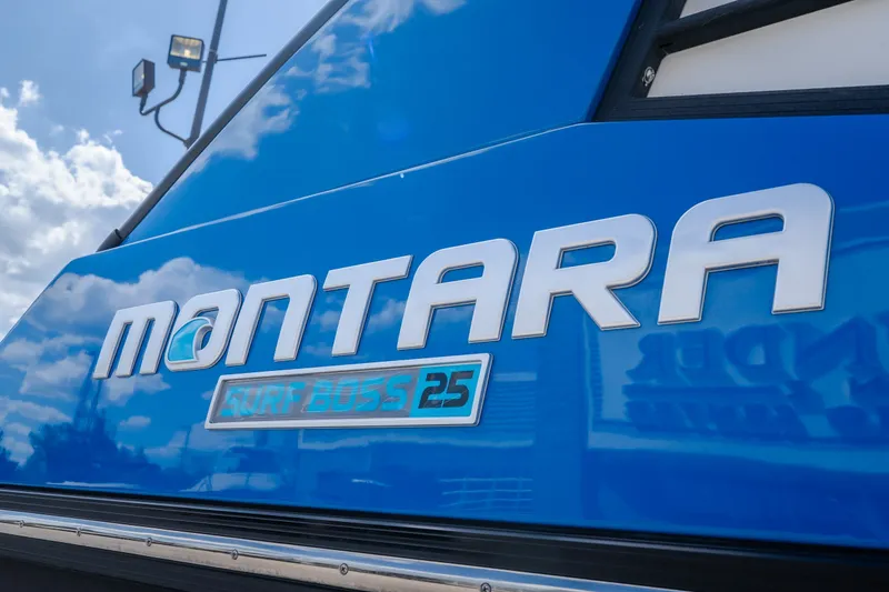 Slide: The Image of 2025 Montara 25 Surf Boss boat logo on blue surface under cloudy sky. - 3