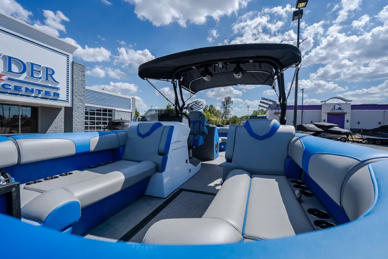 Slide: The Image of 2025 Montara 25 Surf Boss boat interior with blue and gray seating under a sunny sky. - 21