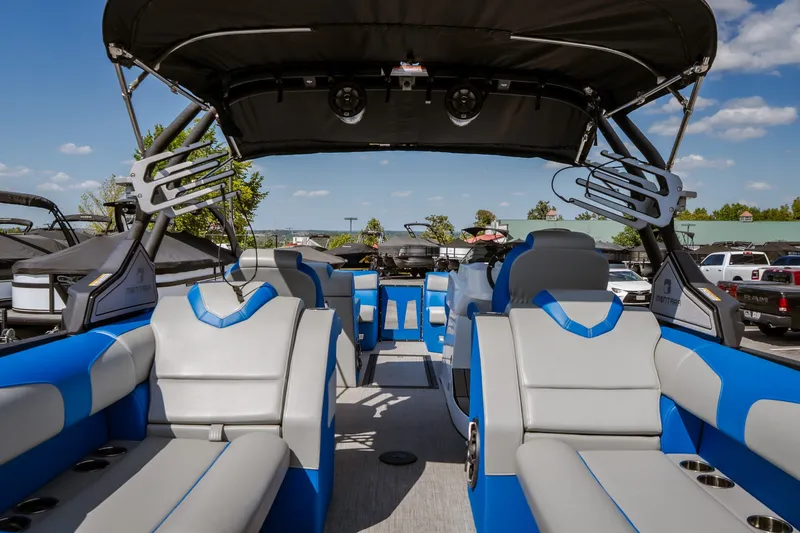 Slide: The Image of 2025 Montara 25 Surf Boss boat interior with blue and gray seating, under sunny skies. - 39