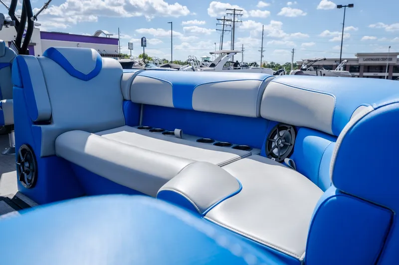 Slide: The Image of 2025 Montara 25 Surf Boss boat interior with blue and gray seating, cup holders, and speakers. - 23