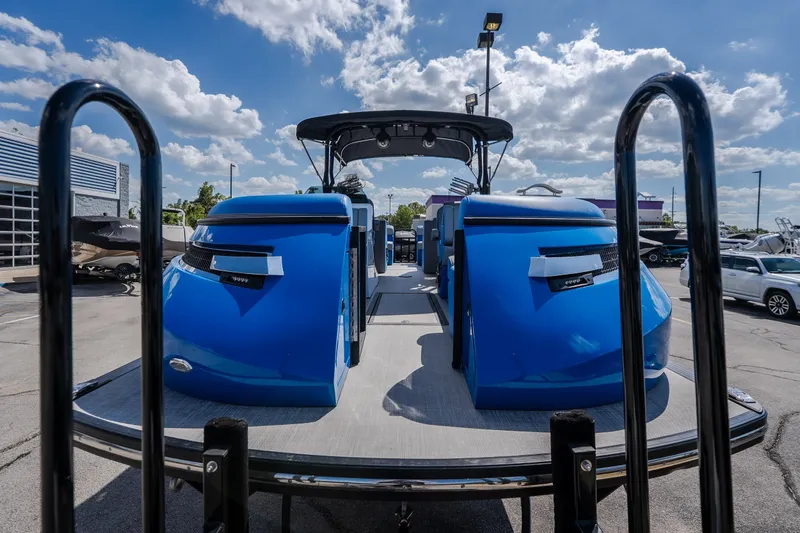 Slide: The Image of 2025 Montara 25 Surf Boss boat with vibrant blue seating, displayed outdoors under a sunny sky. - 19