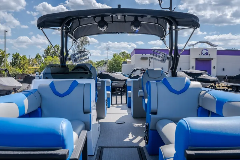 Slide: The Image of 2025 Montara 25 Surf Boss boat interior with blue and gray seating under a sunny sky. - 20