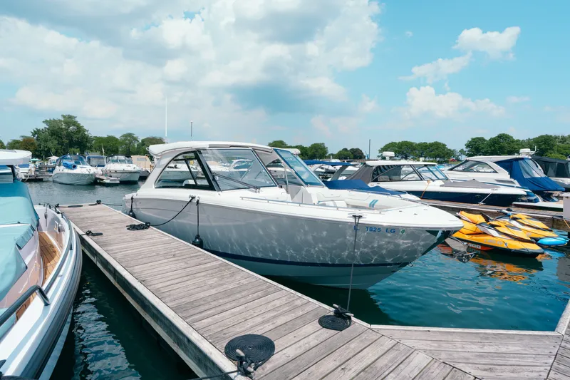 Slide: The Image of 2023 Regal LS36 boat docked at a marina under a partly cloudy sky. - 19