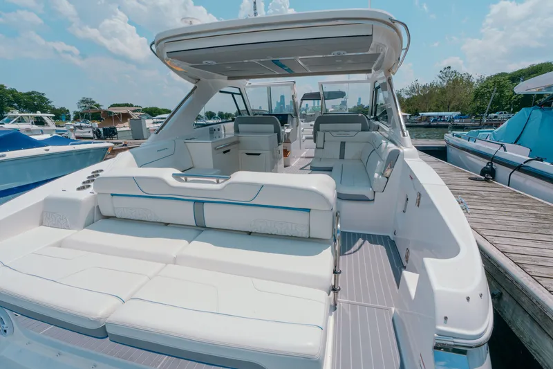 Slide: The Image of 2023 Regal LS36 luxury boat with spacious seating at a marina dock. - 22