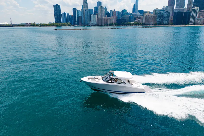 Slide: The Image of 2023 Regal LS36 boat cruising on blue water with city skyline in the background. - 16