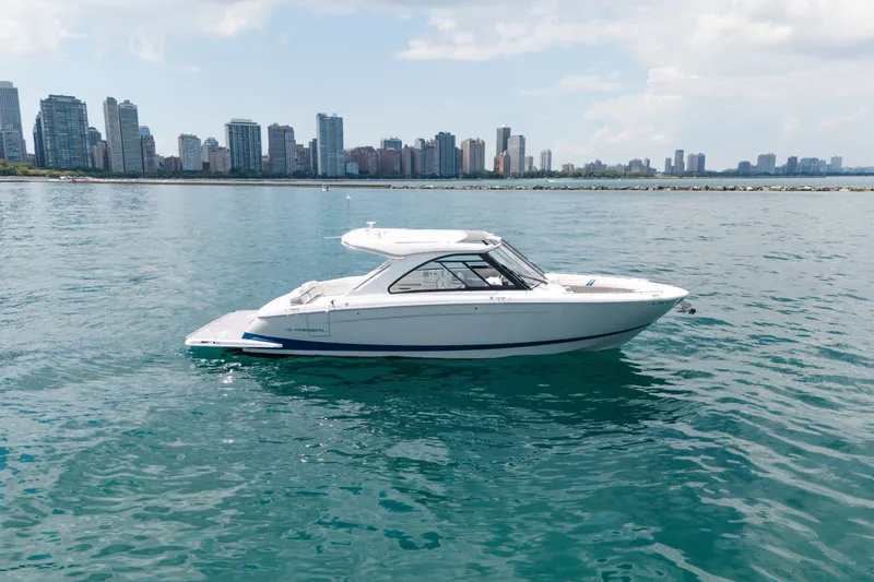 The Image of 2023 Regal LS36 boat on water with city skyline in background. - 3