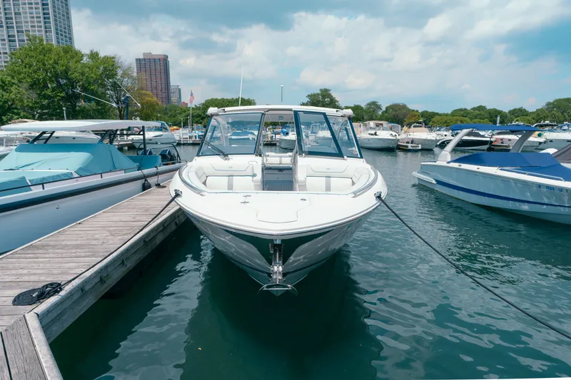 Slide: The Image of 2023 Regal LS36 boat docked at a marina, surrounded by other boats and cityscape. - 20