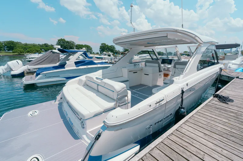 Slide: The Image of 2023 Regal LS36 luxury boat docked at marina under blue sky. - 21