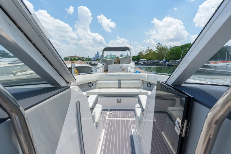 Slide: The Image of 2023 Regal LS36 luxury boat interior with seating, docked under a bright sky. - 29