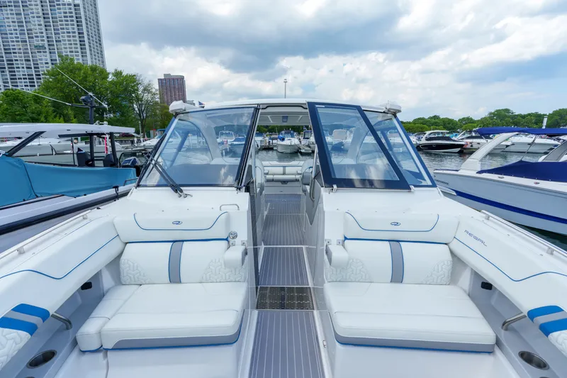 Slide: The Image of 2023 Regal LS36 luxury boat interior with white seating, docked at marina. - 31