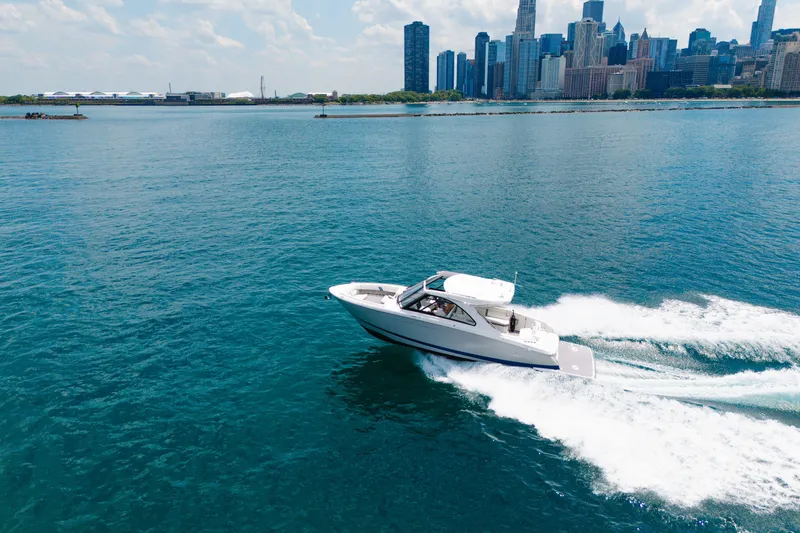 Slide: The Image of 2023 Regal LS36 boat cruising on blue water with city skyline in background. - 15
