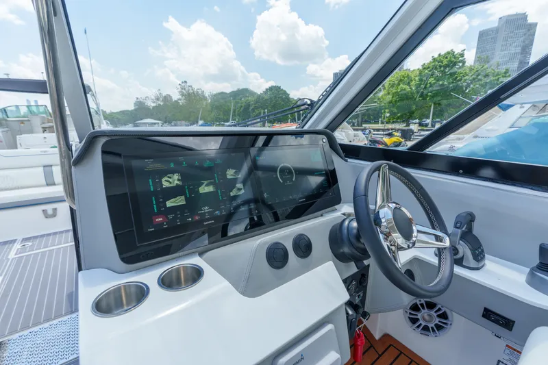 Slide: The Image of 2023 Regal LS36 boat helm with touchscreen display and steering wheel. - 28