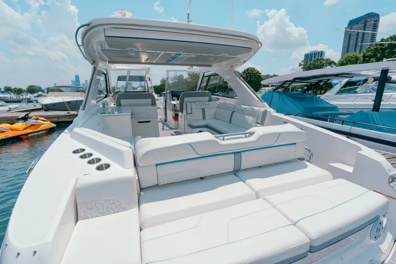 Slide: The Image of 2023 Regal LS36 luxury boat with spacious seating at a marina. - 23