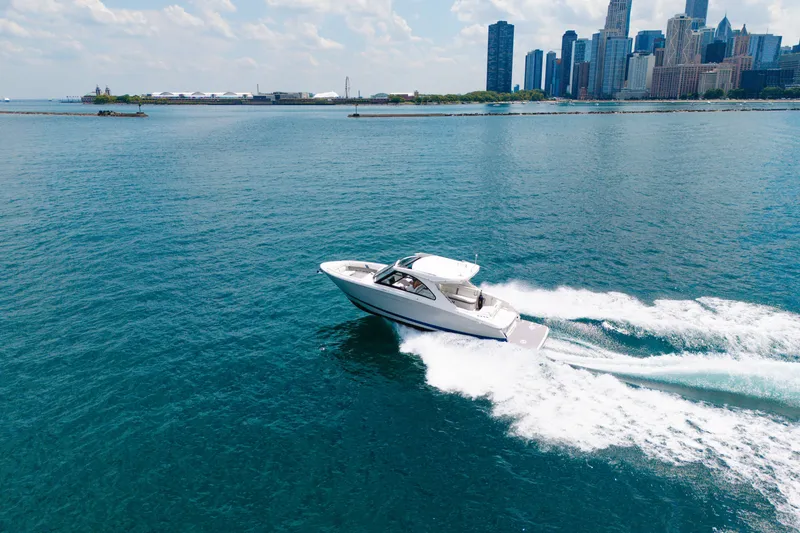 Slide: The Image of 2023 Regal LS36 boat cruising on blue water near city skyline. - 14