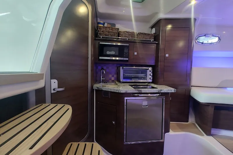 Slide: The Image of 2020 Boston Whaler 345 Conquest interior kitchen with modern appliances and wood finish. - 24