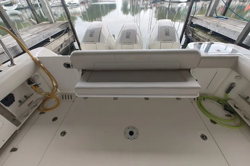 Slide: The Image of 2020 Boston Whaler 345 Conquest boat deck with seating and triple Mercury outboard engines. - 20