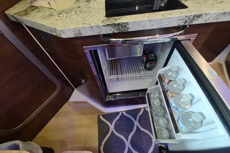 Slide: The Image of Compact refrigerator in 2020 Boston Whaler 345 Conquest cabin, stocked with drinks. - 25