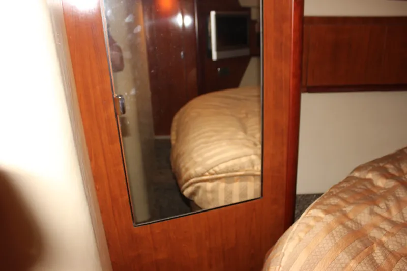 Slide: The Image of Interior cabin of 2006 Sea Ray 40 Sundancer with wood paneling and cozy bedding. - 32