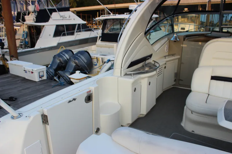 Slide: The Image of 2006 Sea Ray 40 Sundancer yacht interior with seating and kitchenette at marina. - 9