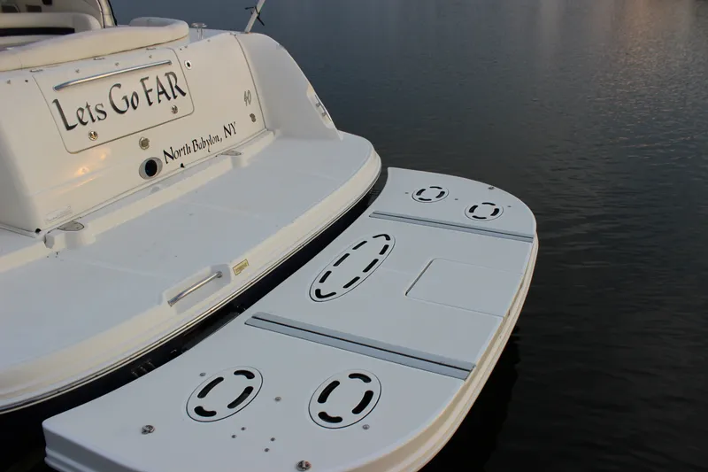 Slide: The Image of 2006 Sea Ray 40 Sundancer boat with "Let's Go FAR" name, docked in calm waters. - 3