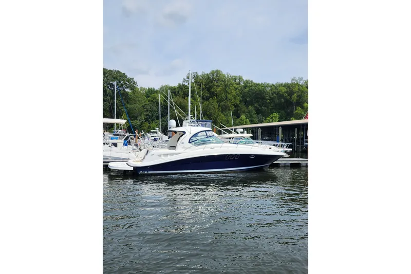 Slide: The Image of 2006 Sea Ray 40 Sundancer yacht docked at marina, surrounded by lush greenery. - 59